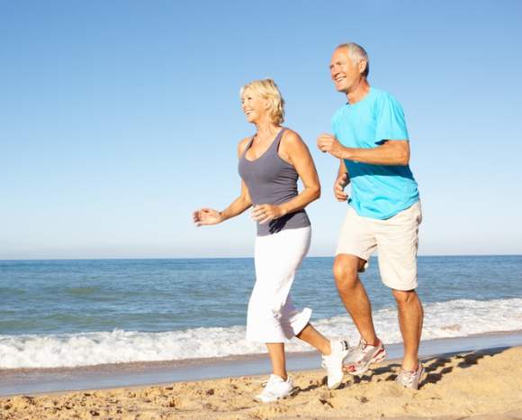 older couple running on the beach 