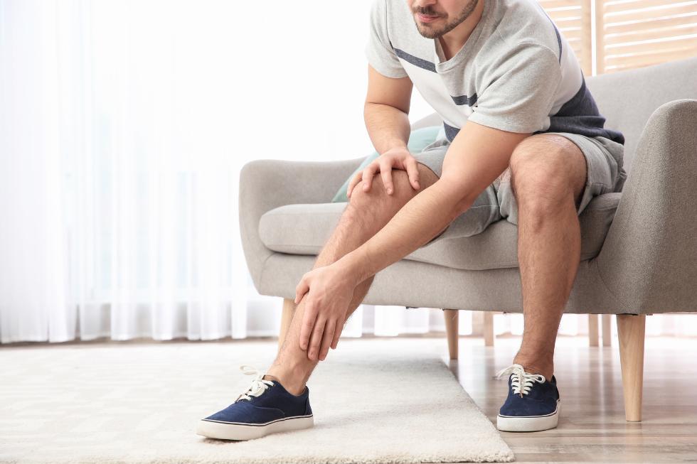 man holding leg sitting on chair